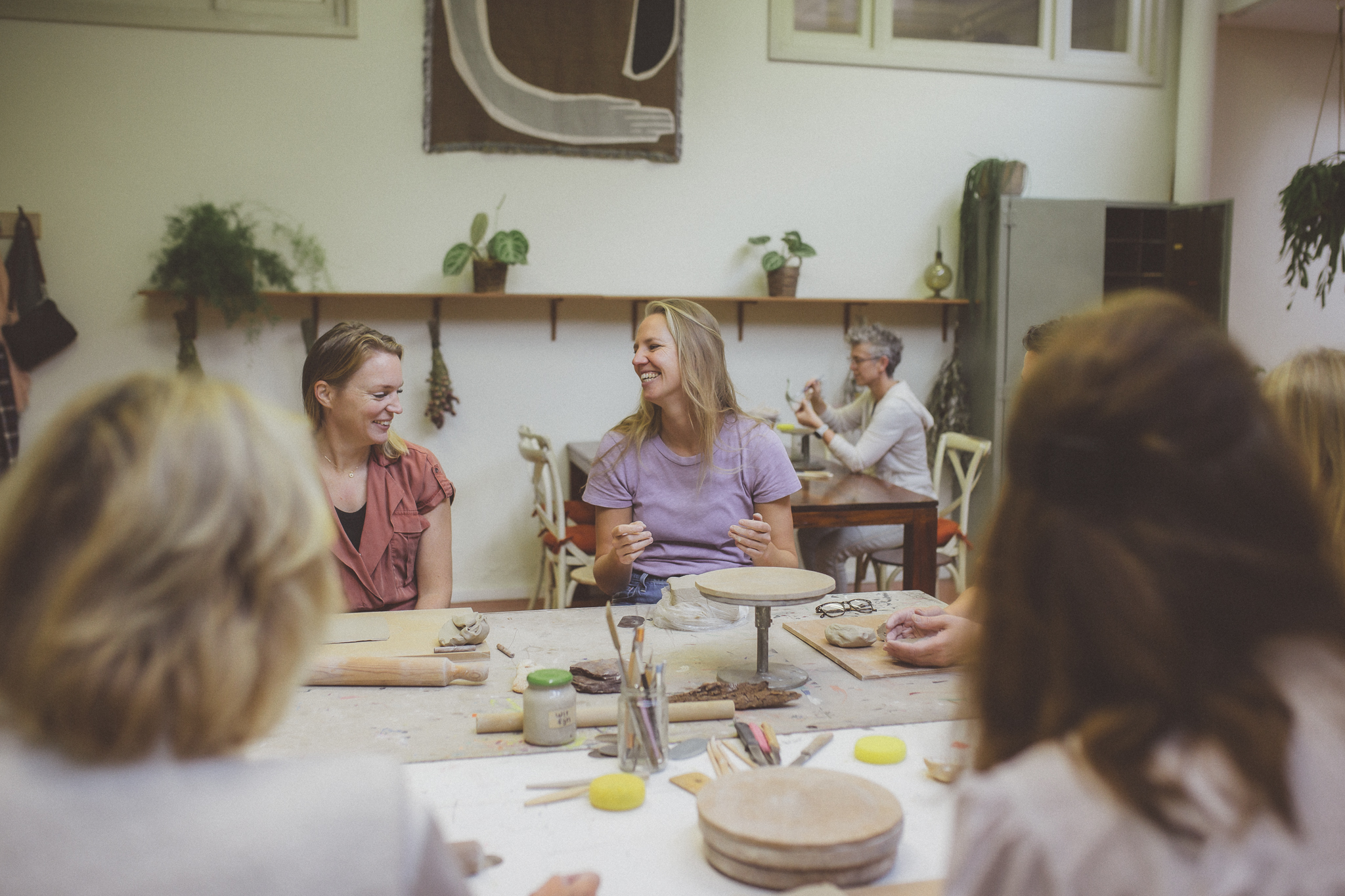 Lolletje tijdens keramiek workshop tussen keramist en deelnemer