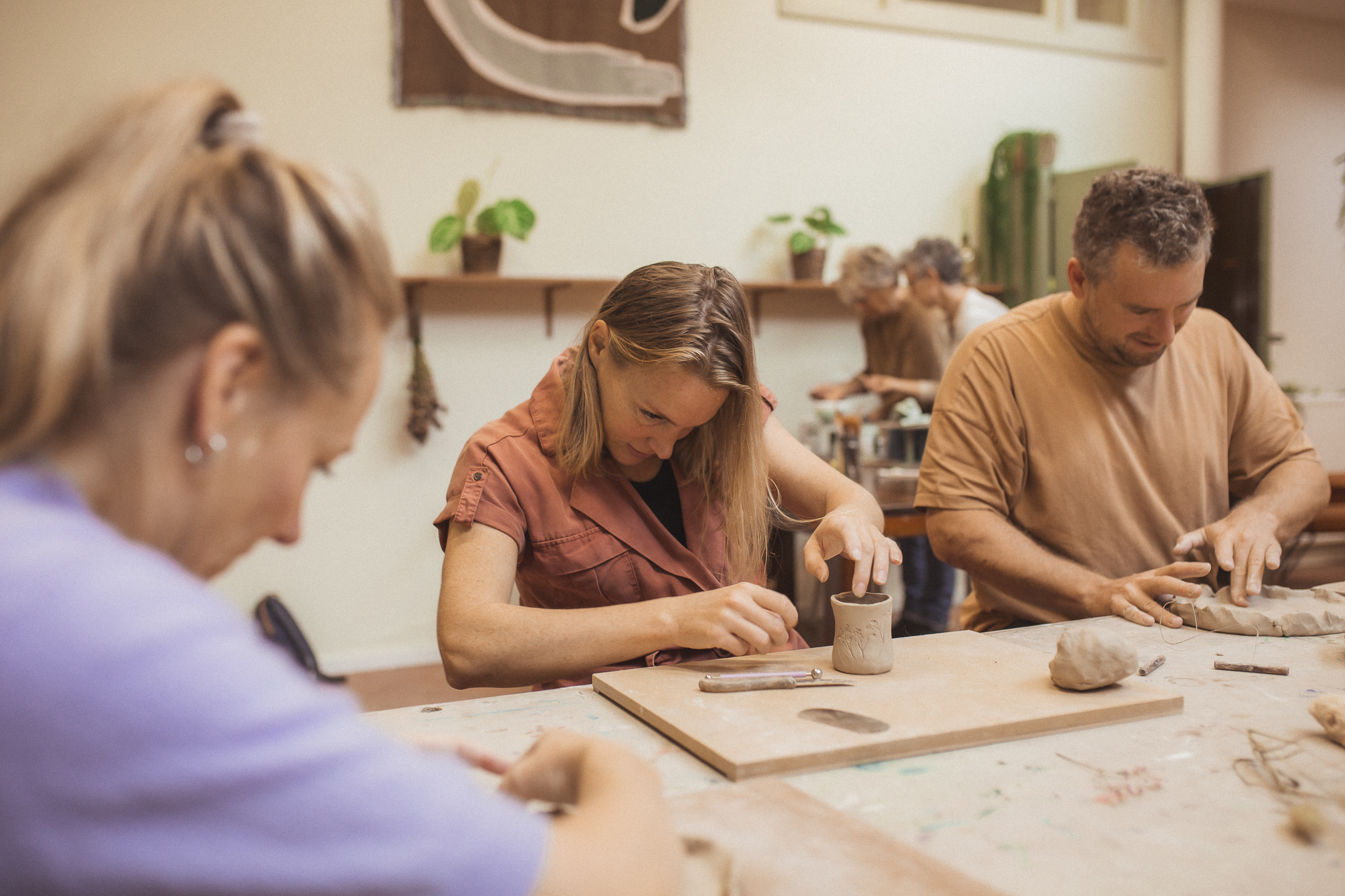 Floor cursist maakt potje met plakken tijdens kleiworkshop