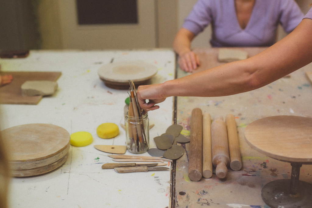 Keramist pakt kleigereedschap tijdens workshop