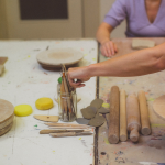 Keramist pakt kleigereedschap tijdens workshop