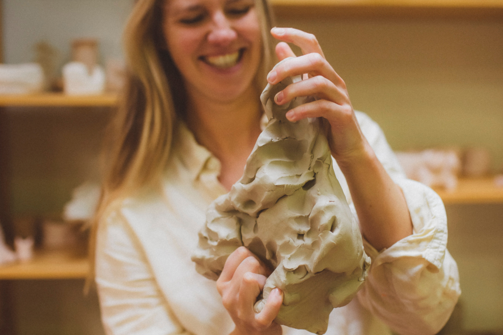 Keramist Stefanie vormt groot stuk klei met hand closeup