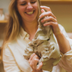 Keramist Stefanie vormt groot stuk klei met hand closeup