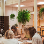 Lichte keramiekstudio met veel ruimte en plannen met cursisten aan het creëren