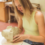 Stefanie vormt de klei met de handen
