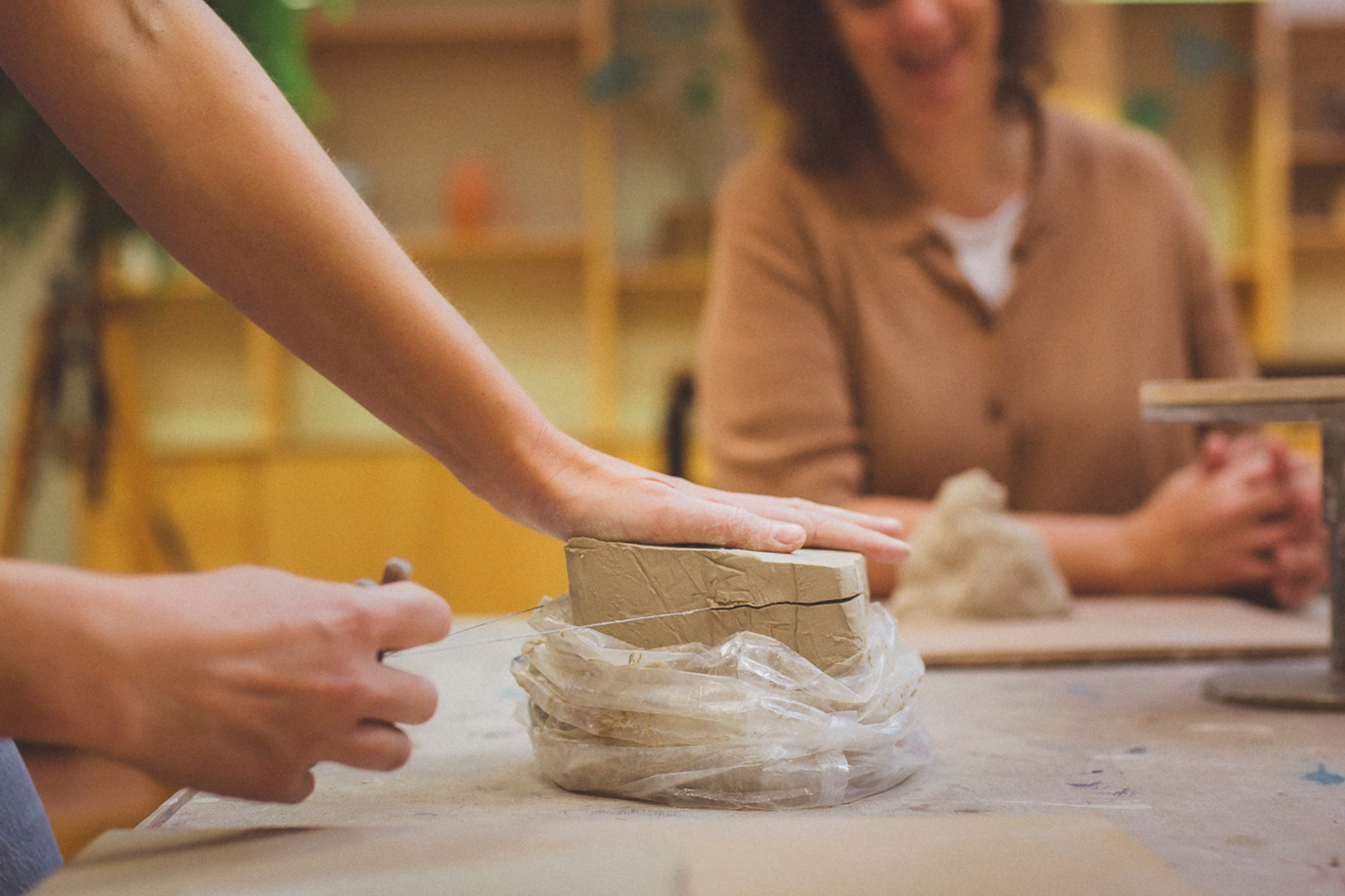 Handen snijden klei tijdens handvormen kennismakingsworkshop bij Kleistudio Elv