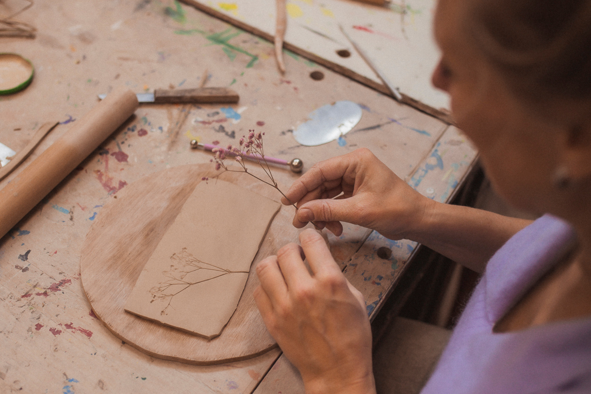 Deelnemer maakt afdruk met bloem ter decoratie van creatief werkstuk